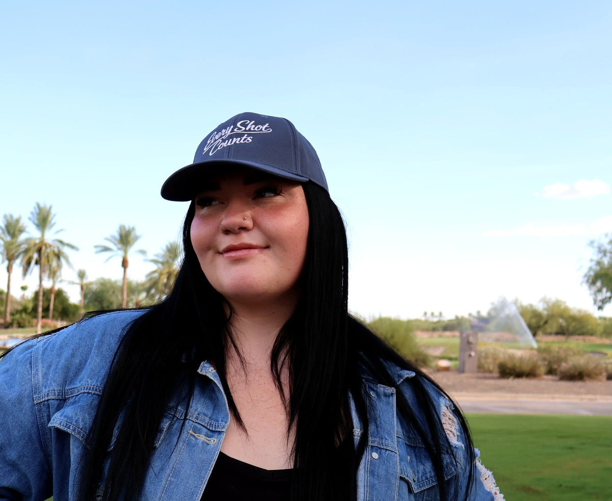 Woman wearing the navy Every Shot Counts golf hat at Vistancia Golf Club