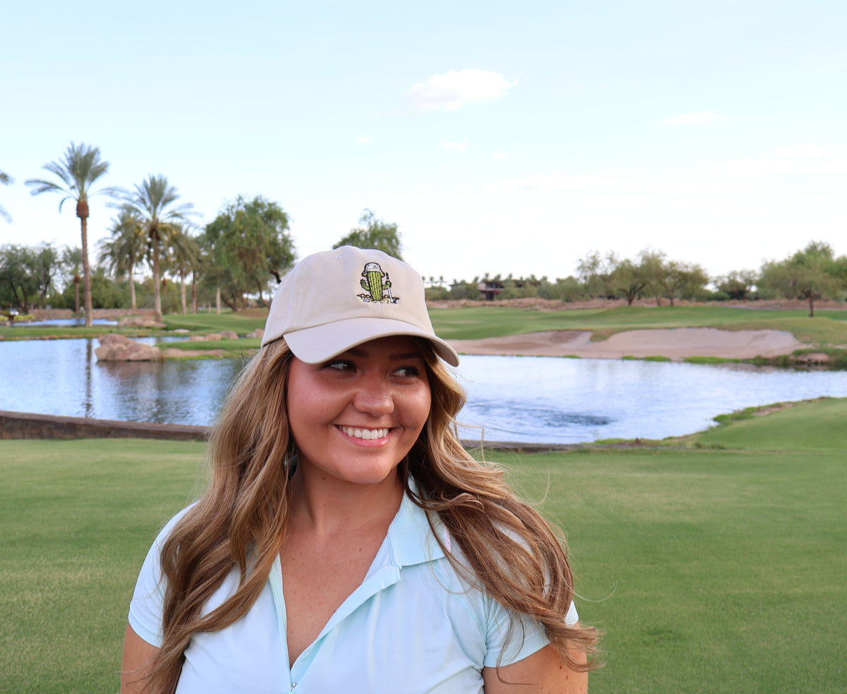 Woman wearing the stone Golf Cactus embroidered dad hat at Vistancia Golf Club