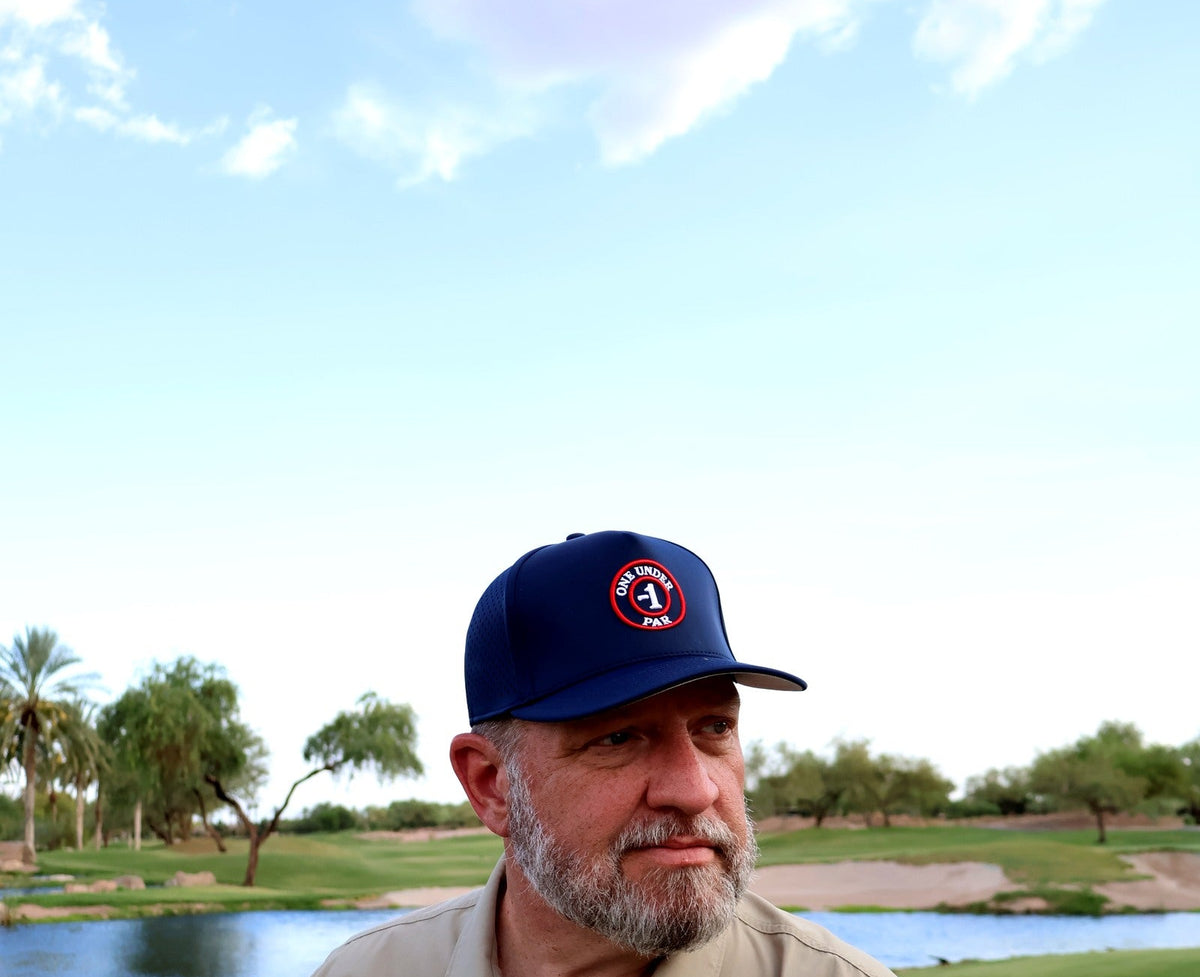 Golfer wearing the navy One Under Par Emblem performance hat on the course