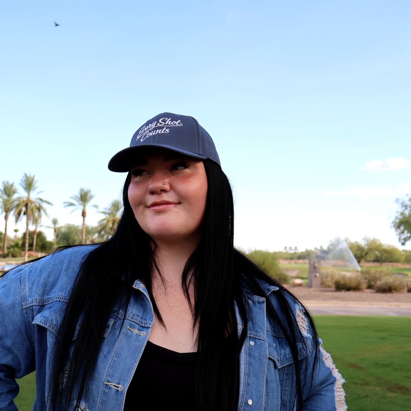 Woman wearing the navy Every Shot Counts golf hat at Vistancia Golf Club