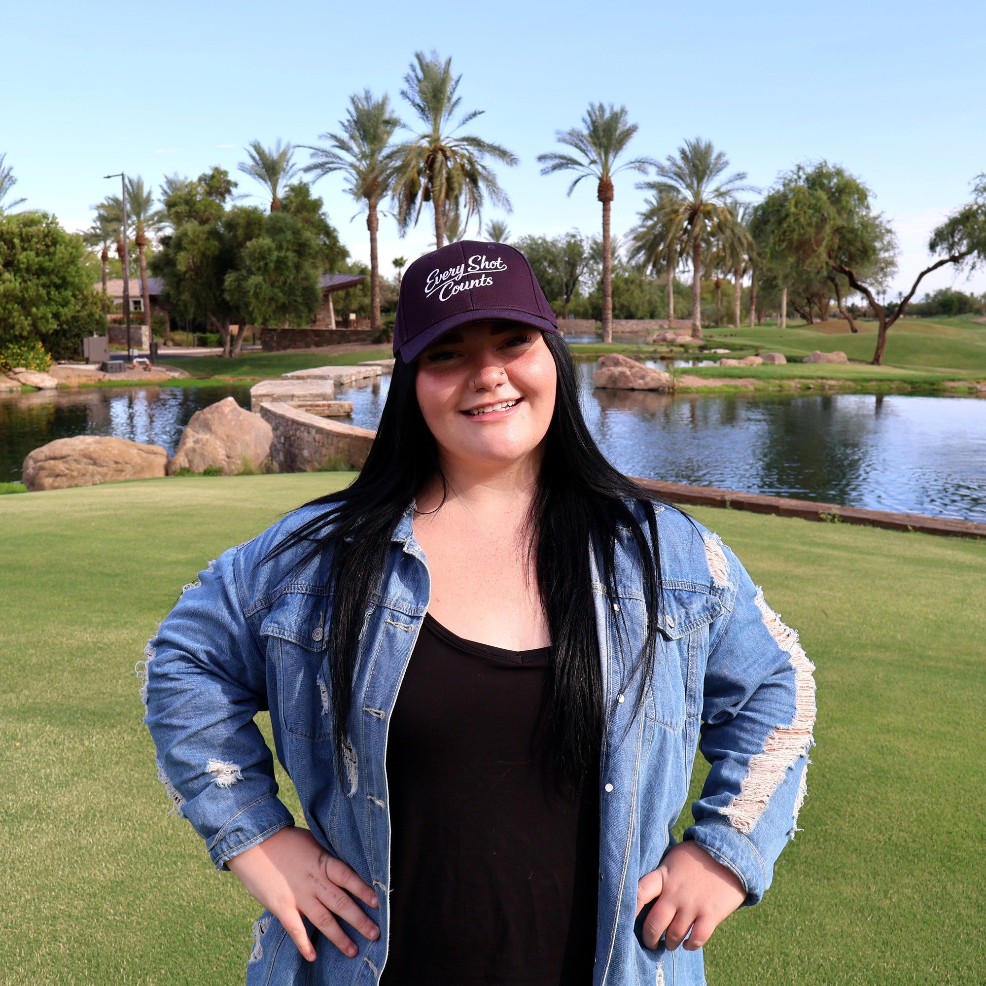 Woman wearing the navy Every Shot Counts embroidered golf hat on the course