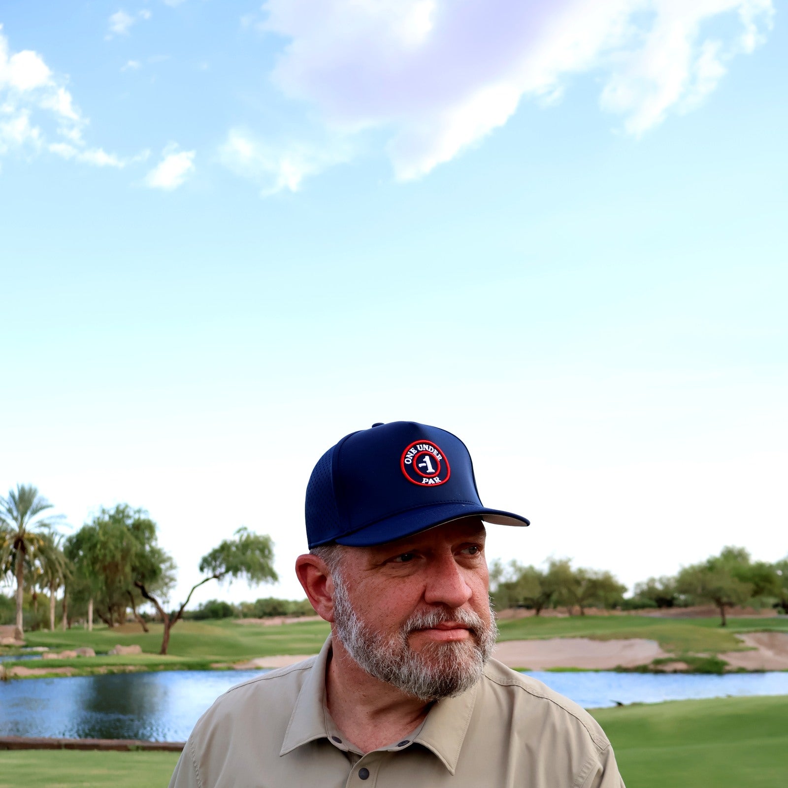 Golfer wearing the navy One Under Par Emblem performance hat on the course