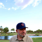 Golfer wearing the navy One Under Par Emblem performance hat on the course